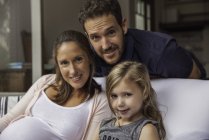 Ritratto di Famiglia con figlia seduta sul divano di casa — Foto stock