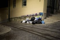 Garbage on side of cobblestone street — Stock Photo