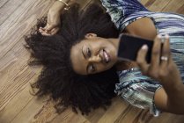 Женщина делает селфи со смартфоном — стоковое фото