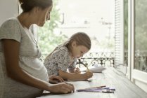 Mother and daughter coloring together — Stock Photo