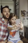 Pai posando para selfie com filha em casa — Fotografia de Stock