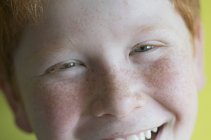 Porträt eines fröhlich lächelnden Jungen mit Sommersprossen — Stockfoto