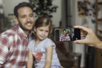 Mano de mujer Fotografiando padre e hija con smartphone - foto de stock
