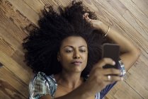 Над головой вид женщины, делающей селфи со смартфоном — стоковое фото