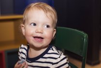 Ritratto del bambino sorridente seduto sulla sedia — Foto stock
