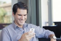 Mann benutzt Smartphone und lächelt fröhlich — Stockfoto