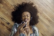 Woman listening to music playing on smartphone — Stock Photo