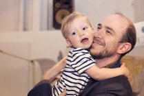 Kleinkind umarmt lächelnden Vater — Stockfoto