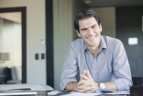 Portrait of smiling Businessman sitting at desk — Stock Photo