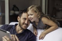 Отец и дочь используют цифровой планшет вместе — стоковое фото