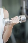 Cropped image of Woman lifting dumbbell — Stock Photo