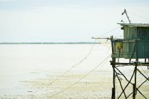 Риболовля хатини на палях біля водного краю — стокове фото