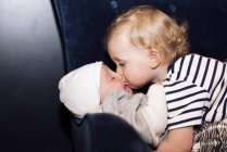Niño abrazando a su hermano pequeño - foto de stock