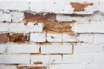 Gros plan du mur de briques détériorant — Photo de stock
