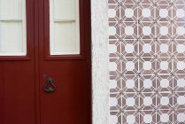Puerta roja y pared de azulejos ornamentados, Lisboa, Portugal - foto de stock