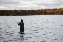 Hombre pescando en el lago usando caña de pescar - foto de stock
