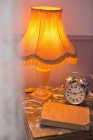 Lamp, alarm clock on bedside table — Stock Photo
