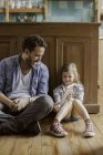 Девочка показывает отцу цифровой планшет дома — стоковое фото