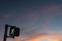 Walk signal with sunset in the background — Stock Photo