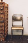 Chair next to old chest of drawers — Stock Photo