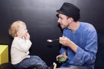 Father feeding toddler ice cream with spoon — Stock Photo