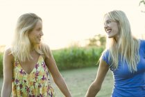 Female couple walking and holding hands outdoors — Stock Photo