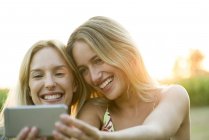Пара женщин позирует для селфи на смартфоне — стоковое фото