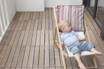Baby reclining on lounge chair — Stock Photo