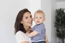Porträt einer glücklichen Mutter, die einen kleinen Jungen hält — Stockfoto