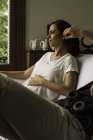 Donna incinta che sperimenta disagio seduta sul divano con il marito — Foto stock