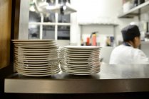 Stack di piatti su scaffale in cucina commerciale — Foto stock