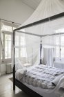 Cama de dossel com mosquiteiro no quarto — Fotografia de Stock