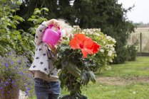 Pequena menina regando plantas em vaso — Fotografia de Stock