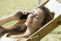 Retrato de mulher falando no celular enquanto toma sol — Fotografia de Stock