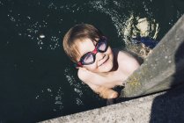 Вид зверху хлопчика з окулярами, що плавають у воді — стокове фото