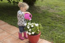 Little girl watering potted plants — Stock Photo
