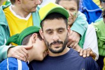 Brazilian football fans consoling each other at match — Stock Photo