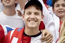 Retrato del partidario del fútbol sonriendo en el partido - foto de stock