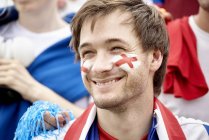 British football fan smiling cheerfully at match — Stock Photo