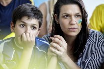 Mother and son watching football match at home — Stock Photo