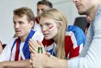 British football fans watching match together at home — Stock Photo