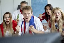 Fãs de futebol britânico torcendo enquanto assiste jogo na TV — Fotografia de Stock