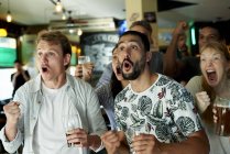 Soccer fans watching match together at pub — Stock Photo