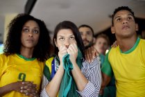 Brazilian football supporters anxiously watching match in bar — Stock Photo