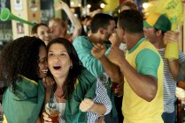 Brazilian soccer fans watching match together at pub — Stock Photo