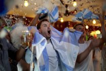Argentinian football fans celebrating victory in bar — Stock Photo