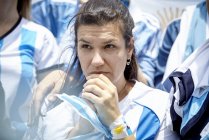 Argentinian football fan watching match with anxious expression on face — Stock Photo