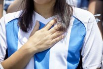 Футбольный болельщик Аргентины держит руку на сердце во время матча — стоковое фото