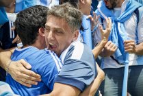 Aficionados argentinos al fútbol abrazándose en un partido de fútbol - foto de stock