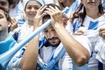 Argentinian football fan holding head in disappointment at match — Stock Photo
